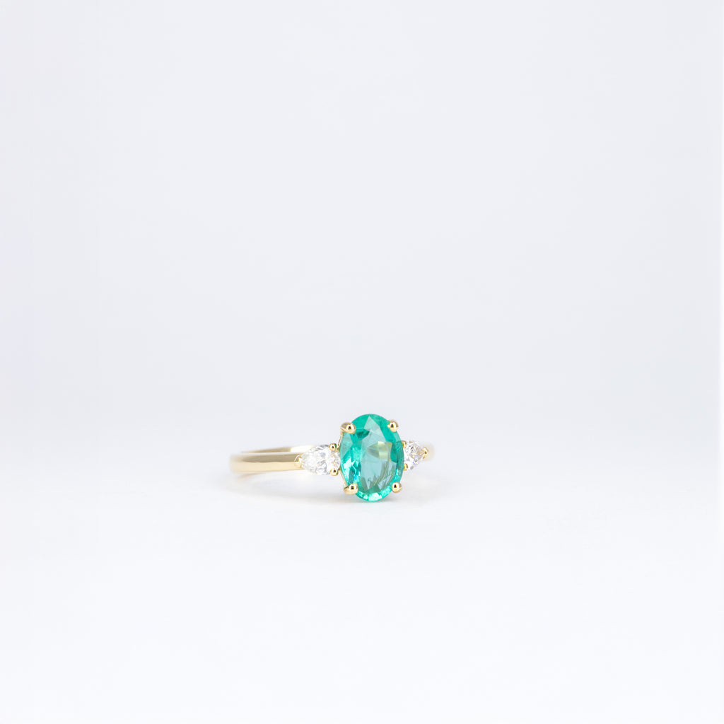Bague en or jaune 18K avec émeraude ovale de 1,06 ct et deux diamants taille poire