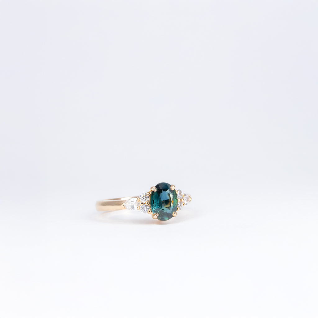 Bague en or rose 18K avec saphir teal ovale et diamants taille brillant et poire