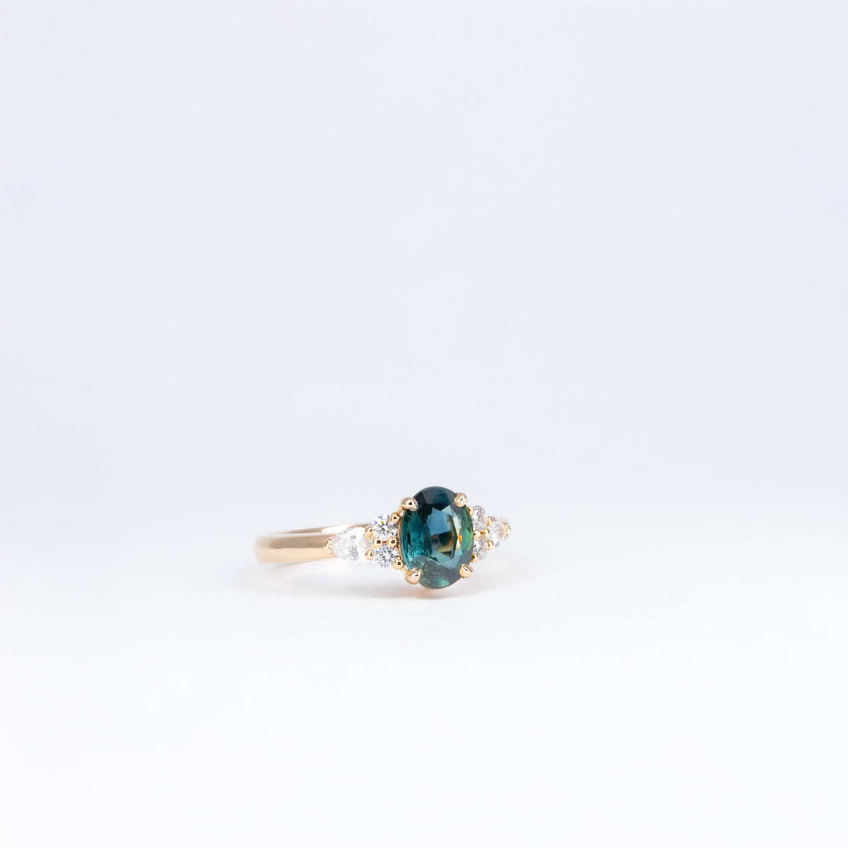 Bague en or rose 18K avec saphir teal ovale et diamants taille brillant et poire