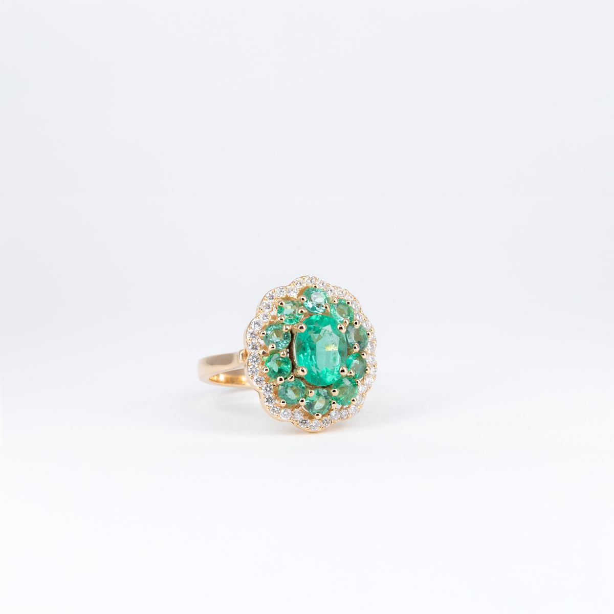Bague en or rose 18K avec émeraude ovale, émeraudes rondes et entourage de diamants